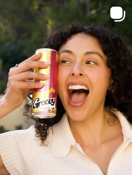 Woman laughing with a pink and yellow Groovy Social can